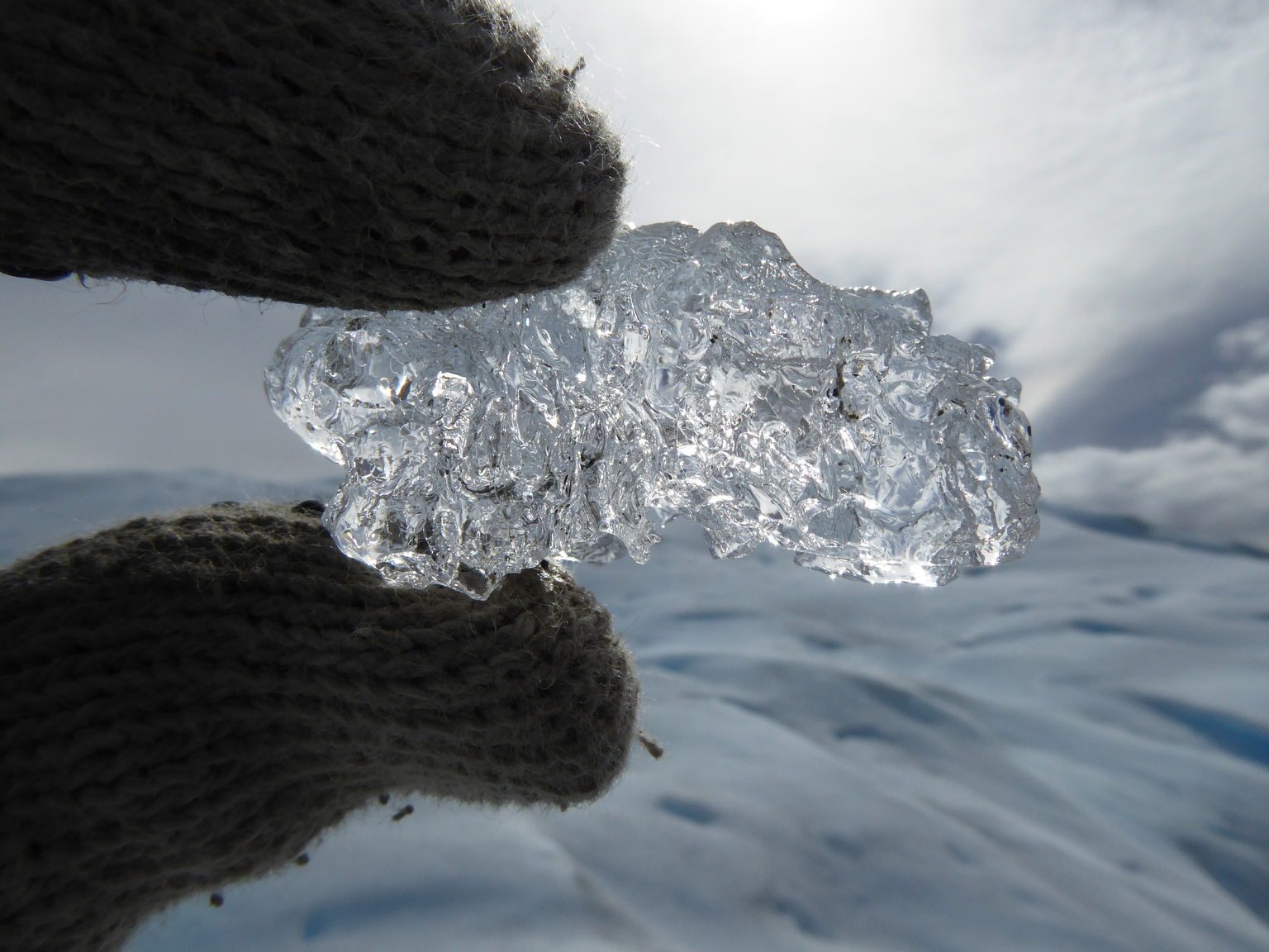 Glacial ice is so clear because the weight of all the layers creates larger ice crystals. Because ice absorbs more long wavelength light (like red and yellow), when you see light coming through a lot of ice, it looks blue. Science!