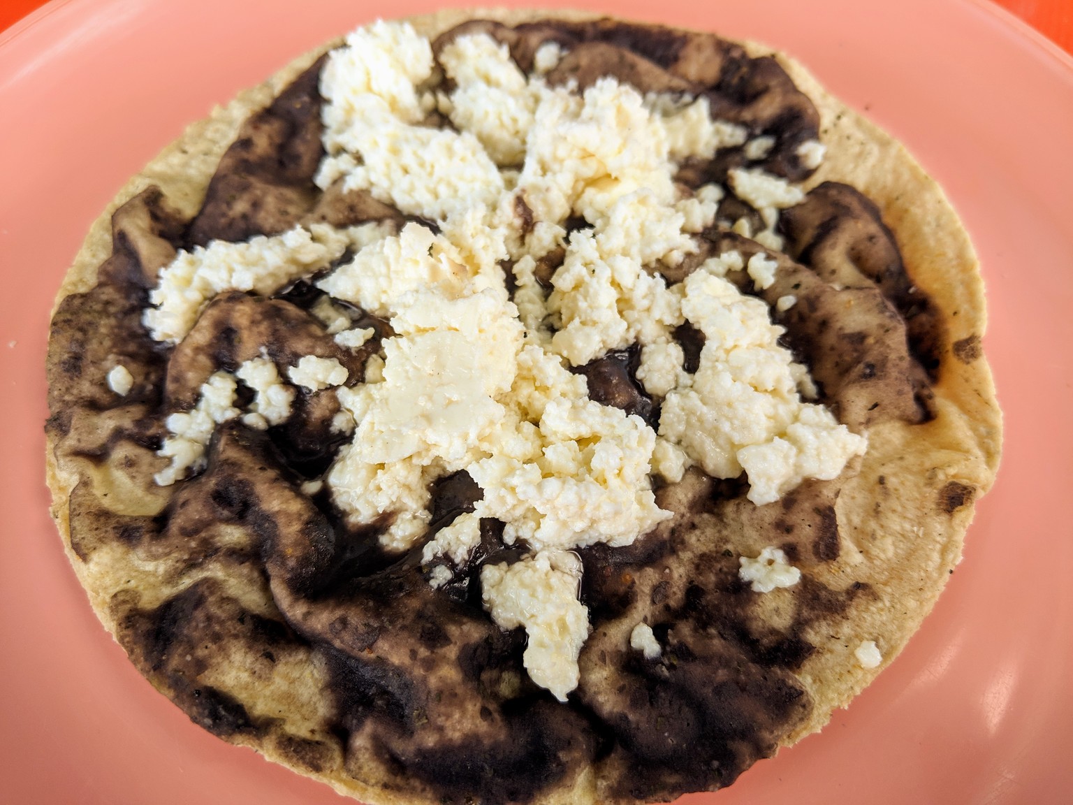 A memela, fresh masa corn tortilla, black beans and queso fresco.