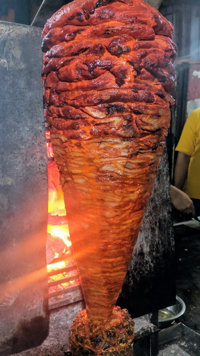 Al pastor meat cooking on a spit
